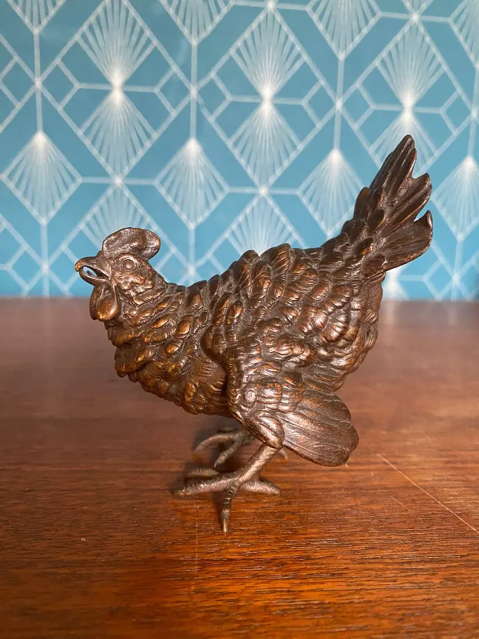 Bronze animalier des années 1920, signé Geschut et numéroté," La petite poule en alerte", à la patine brune du plus bel effet. En excellent état elle mesure 9cm de haut. Animal bronze from the 1920s, signed Geschut and numbered, "The little hen on alert", with a brown patina of the most beautiful effect. In excellent condition, it measures 9cm high.