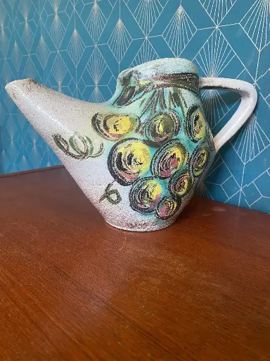 Accolay, splendide pichet des années 50, signé dans la masse, en excellent état. Design stylisé à décors de grappes de raisins, 20cm de hauteur. superbe pièce rare.                    Accolay, a splendid pitcher from the 1950s, signed throughout, in excellent condition. Stylized design with grape cluster decorations, 20cm tall. A superb rare piece.